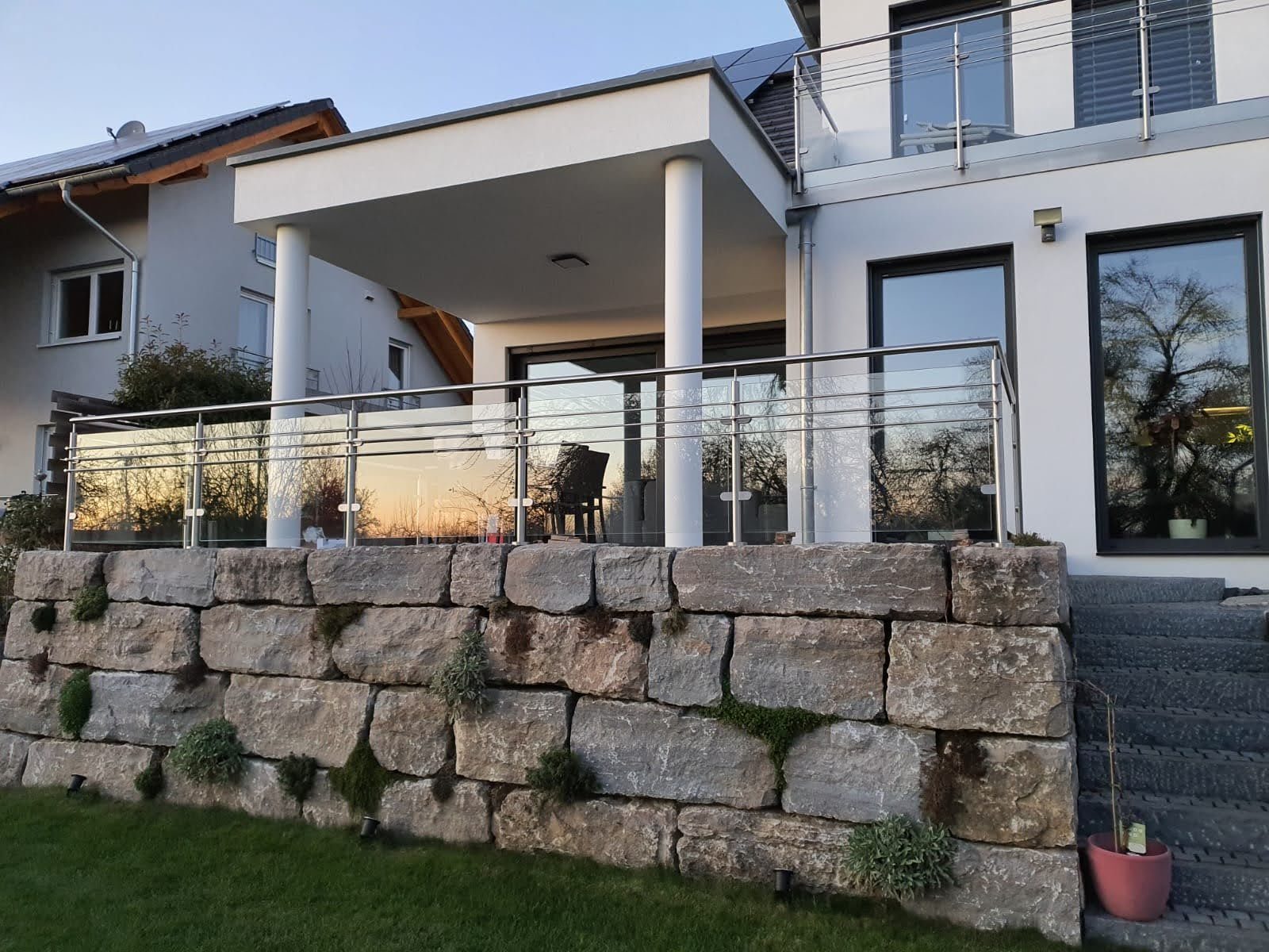 Glasgeländer auf Natursteinmauer