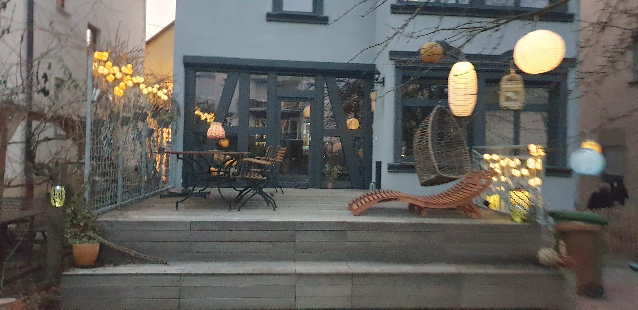 Bunte Lampions im Baum über der Terrasse